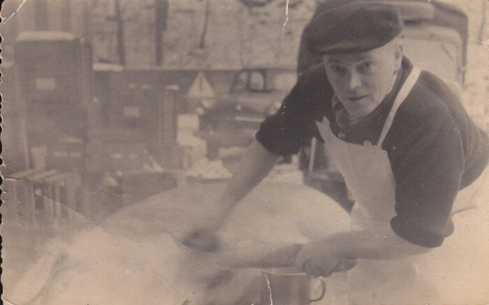 Gerhard Fessel bei der Arbeit in der Fleischerei Fessel. Historisches Foto in schwarz-weiß.